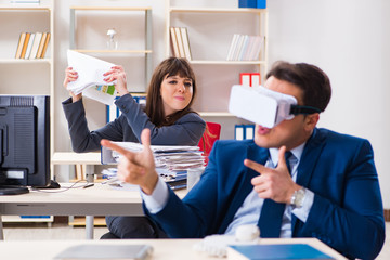 Employee with virtual reality glasses in office