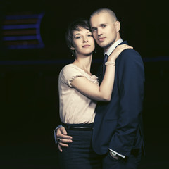 Happy young fashion couple in love walking in night city street