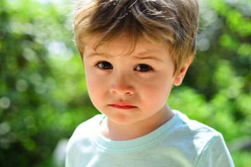 Sad child, close-up portrait. A frustrated child without mood. Sad emotions on a beautiful face. Child in nature. Fatigue after a walk. Sad childish look, disappointment in the eyes