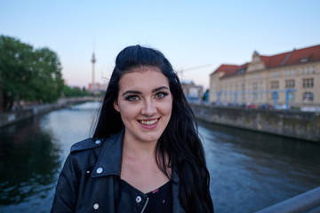 Junge Frau auf Spree Brücke lächelt vor Berliner Fernsehturm