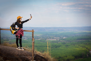 Woman enjoying in nature and taking picture in the mountain with mobile phone.