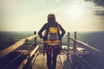 Obraz premium Tourist young woman wearing hat enjoying stand in wood bridge on the mountains.
