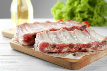 Board with fresh raw pork ribs on wooden table