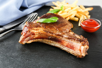 Delicious grilled rib and tomato sauce on slate plate, closeup
