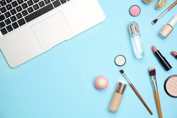 Flat lay composition with laptop and makeup products for woman on color background