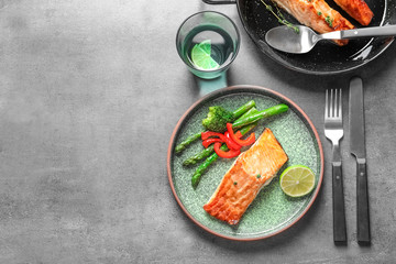 Plate with tasty cooked salmon served for dinner on table, top view