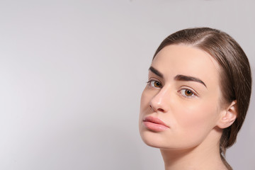 Fototapeta premium Beautiful woman with perfect eyebrows on light background