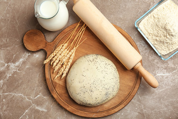 Composition of raw dough with poppy seeds on table
