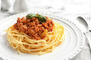 Plate with delicious pasta bolognese on table