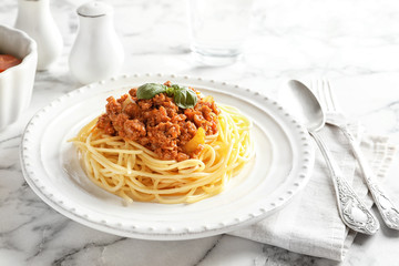Plate with delicious pasta bolognese on table