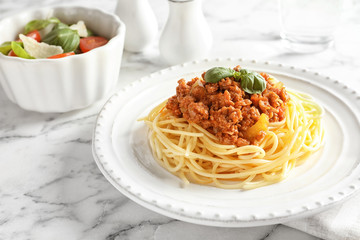 Plate with delicious pasta bolognese on table