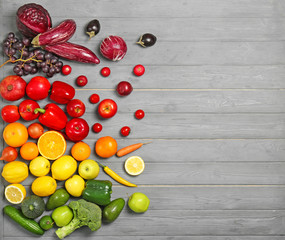 Rainbow composition with fresh vegetables and fruits on wooden background, flat lay