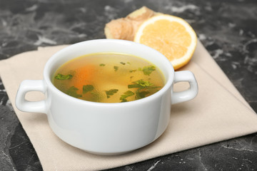 Dish with delicious hot broth on table. Cold treatment