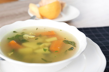 Bowl with delicious hot broth on table. Cold treatment