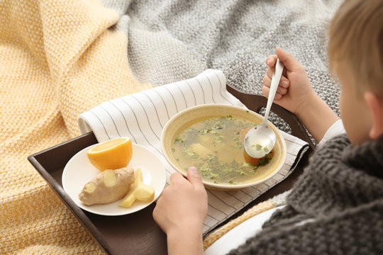 Sick Little Boy Eating Broth To Cure Cold In Bed At Home