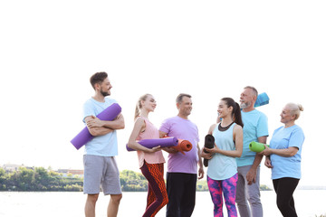 Group of people talking after yoga class near river on sunny day
