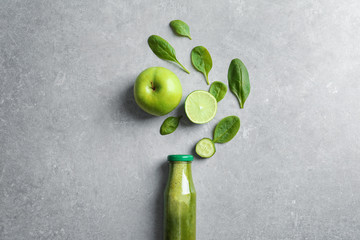 Flat lay composition with bottle of delicious detox juice and ingredients on grey background