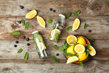Flat lay composition with detox lemonade and ingredients on wooden background