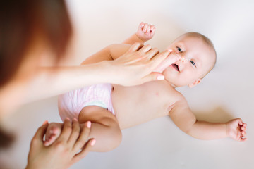 Baby massage. Mother massaging and doing gymnastic with legs of her kid