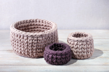 Fototapeta na wymiar Knitted baskets on a wooden table. Handmade crochrting background.
