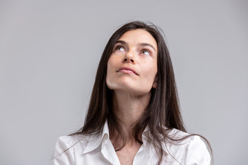 Obraz premium Thoughtful attractive woman looking up