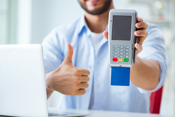 Man processing credit card transaction with POS terminal
