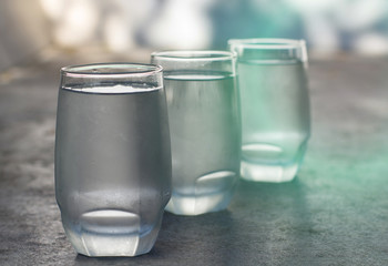 row of ice cold water glass with blue light effect
