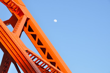 Tokyo Tower and daytime moon, Tokyo landmark with blue sky.
