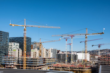Fototapeta na wymiar Construction building with cranes and derrick