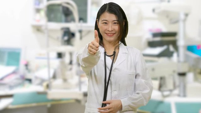Asian female doctor showing thums up in clinic