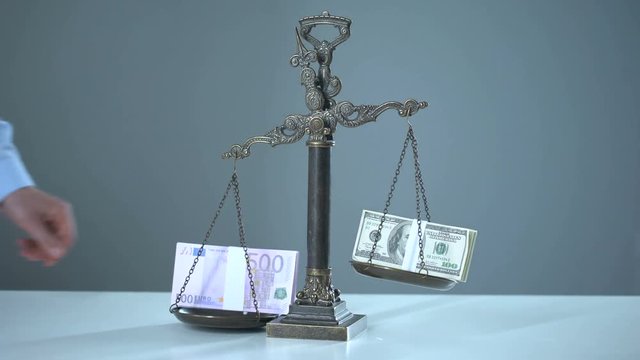 Euro dominates dollar on scales, exchange rates concept, stock market trading