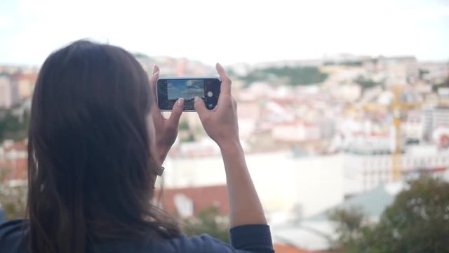 Beautiful girl takes a panorama of the city on the phone. SLOW MOTION. HD, 1920x1080.