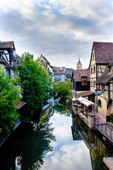 Fototapeta na wymiar Gorgeous view of little Venice in Colmar, Alsace, with the Colmar Cathedral in the background.