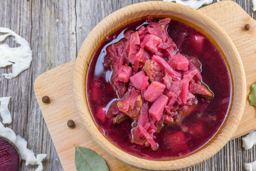 Detailed top view on a Borscht soup from  beetroot and cabbage on a wooden board