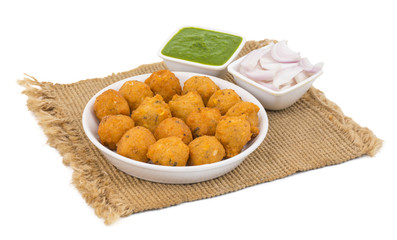 Indian Spicy Street Food Dal Vada Also Know as Moong Dal Vada, Pakoda, Pakode, Pakore, Moong Vada, Pakora or Bhajiya Served with Green Chutney or Onion isolated on White Background