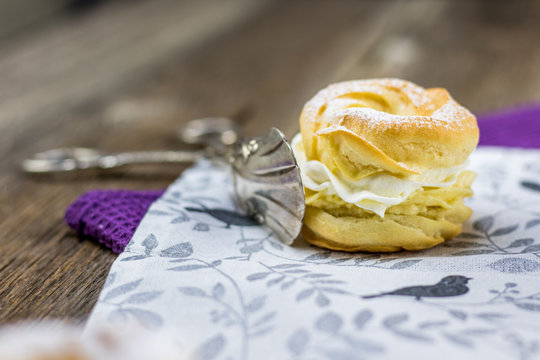 Small wreath with whipped cream (traditional Czech dessert - "venecek") in confectioner pliers