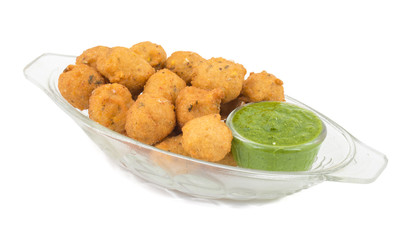 Indian Spicy Street Food Dal Vada Also Know as Moong Dal Vada, Pakoda, Pakode, Pakore, Moong Vada, Pakora or Bhajiya Served with Green Chutney or Onion isolated on White Background