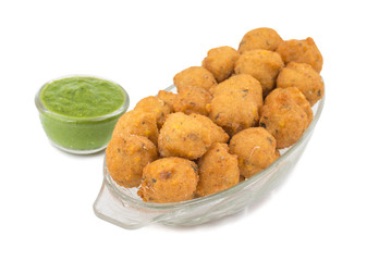 Indian Spicy Street Food Dal Vada Also Know as Moong Dal Vada, Pakoda, Pakode, Pakore, Moong Vada, Pakora or Bhajiya Served with Green Chutney or Onion isolated on White Background