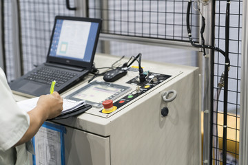 NC Machine control panel closup, automatic robot input program and maintenance