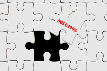 piece of jigsaw puzzle with solution wording for business concept