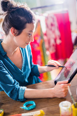 Fashion designer drawing a new model on a digital tablet