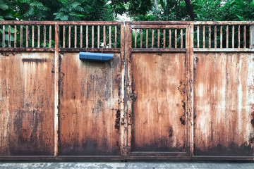 old rusty metal house gate with mailbox