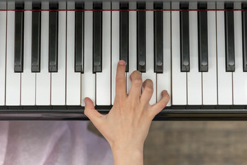 Child's hand on piano keys. Close up of child's hands playing the piano