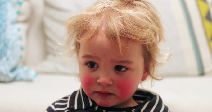 Closeup of blonde child baby infant toddler with red cheaks starring off camera2
