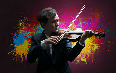 Fototapeta premium Young classical violinist musician with colorful splotch wallpaper 