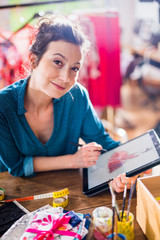 Fashion designer drawing a new model on a digital tablet