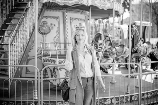 Nice beautiful fashionable woman in an amusement park. Pretty , middle age lady having fun at an amusement park. Joy in adult life 