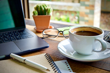 Desk work coffee cup and laptop notebook pen on wooden table