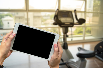 Young man Hand holding smartphone in gym to  fitness phone fitness exercise concept