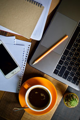 Desk work coffee cup and laptop notebook pen on wooden table